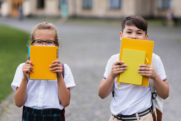 Interracial gyerekek kezében notebook közel arcok szabadban - Fotó, kép