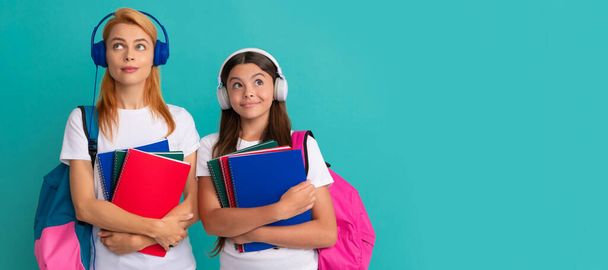 Mother and daughter child banner, copy space, isolated background. thoughtful private teacher and kid in earphones holding textbook and school bag, estudy - Photo, Image