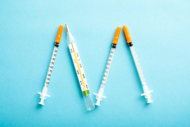 Medical syringes on blue background. Simple medicine concept flat lay. - Zdjęcie, obraz