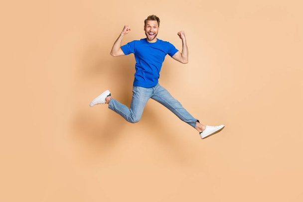 Full size portrait of overjoyed satisfied person raise fists celebrate success isolated on beige color background. - Fotó, kép