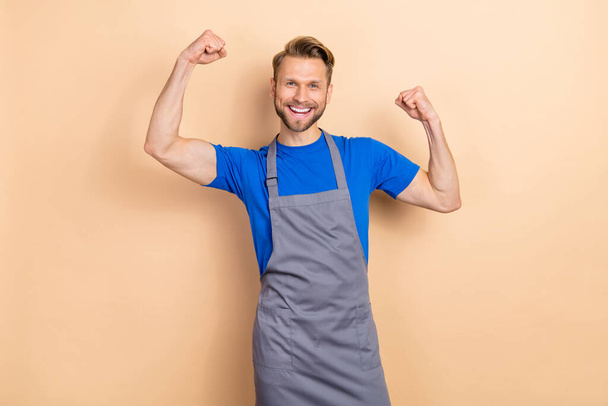 Photo of young excited man celebrate luck fists hands shop-owner sporty biceps isolated over beige color background. - Fotoğraf, Görsel
