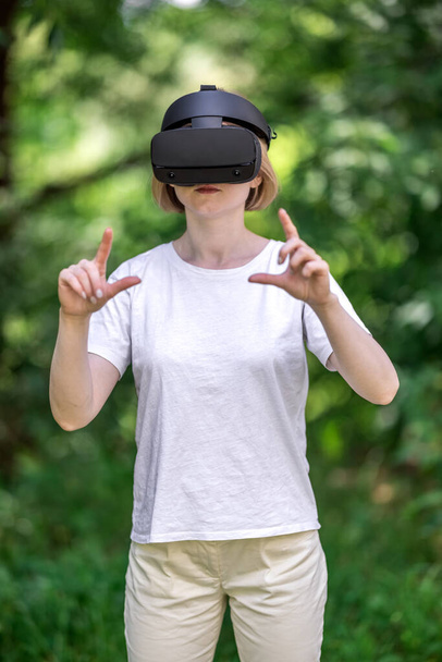 Mujer sonriente interactuando con la realidad virtual
 - Foto, imagen