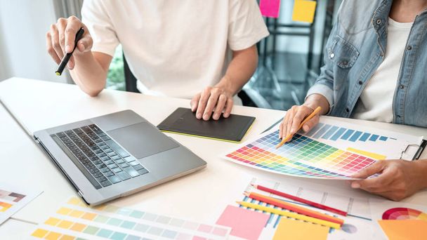 Two creative graphic designer team working on color selection and drawing on graphic tablet, Color swatch samples chart for selection coloring in inspiration to creativity at workplace. - 写真・画像