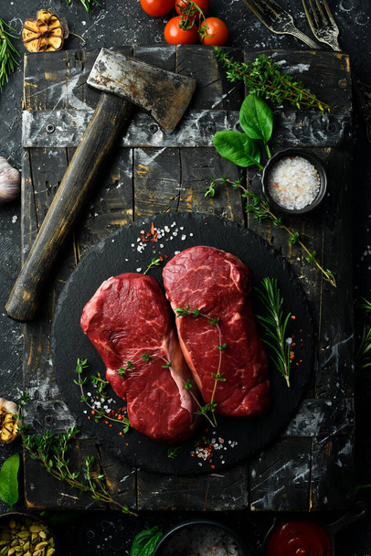 Raw striploin steak (New York) of beef on a board. Top view. On a black stone plate. - Φωτογραφία, εικόνα