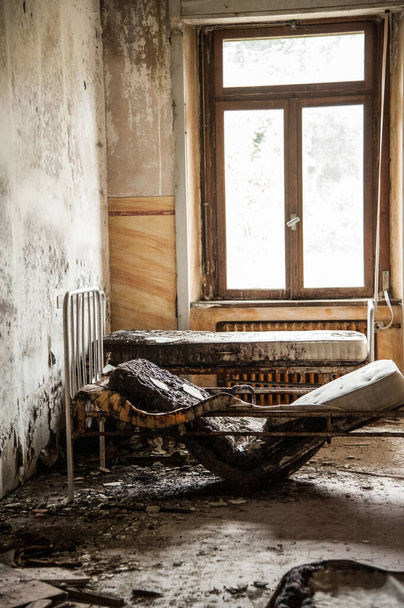 July 2022, Italy, Urbex. Dilapidated room with medical bed in an abandoned college - Foto, afbeelding