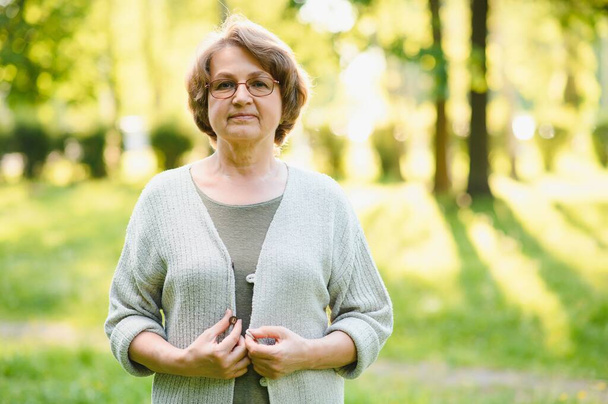 Portrait of a happy Senior woman in summer park. - Fotoğraf, Görsel