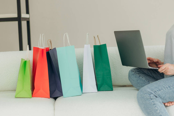 Női vásárlás közelkép Online Laptop használata színes bevásárló táskák - Fotó, kép
