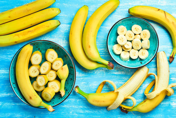 Tropical bananas on a blue wooden background. Top view. - 写真・画像