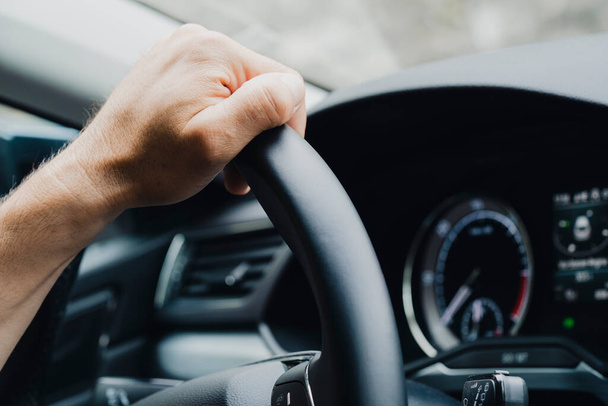 Zbliżenie ujęcia męskich dłoni na kierownicy samochodu. - Zdjęcie, obraz