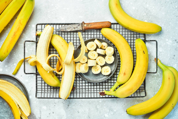 Fresh bananas sliced in a bowl. Tropical bananas on a gray concrete background. Top view. - Fotó, kép