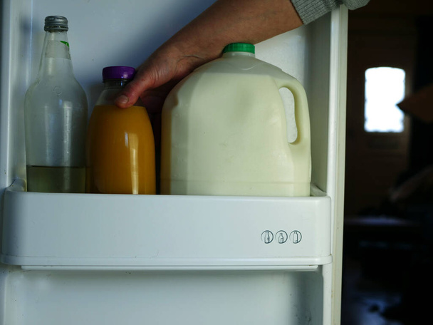 Uvedení ovocné šťávy a mléka do chladničky středního zraku selektivního zaměření - Fotografie, Obrázek