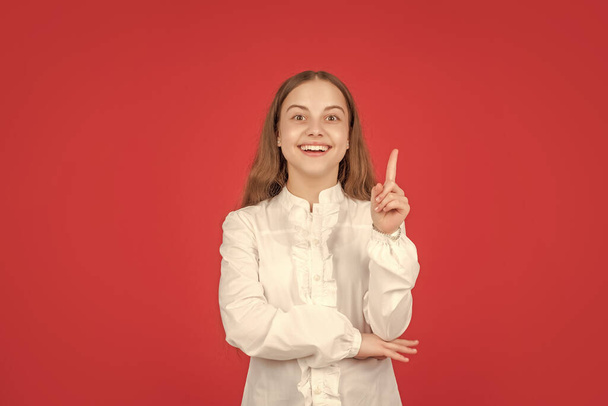 inspired with idea. positive human emotions. inspiration. teen girl with glad face. back to school. education concept. kid in white shirt on red background. childhood. child portrait raised finger. - Fotó, kép