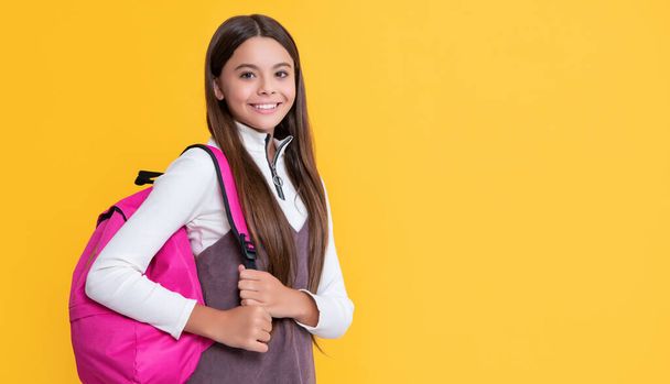 niño feliz con mochila escolar sobre fondo amarillo. - Foto, Imagen
