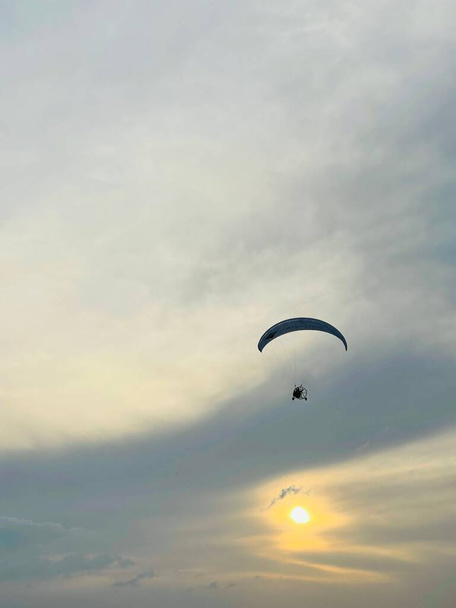 Parapente piloto volar en el cielo en la belleza naturaleza montaña y mar costa paisaje Crimea fondo, foto vertical. espacio de copia. Concepto de parapente - Foto, imagen