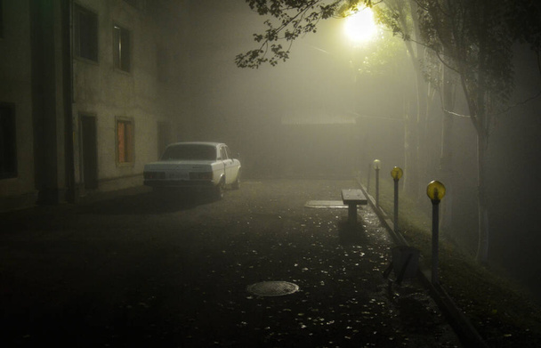 Nachtherbstlicher Bauhof mit geparktem Auto und Laternenlicht nach Regen im Nebel - Foto, Bild