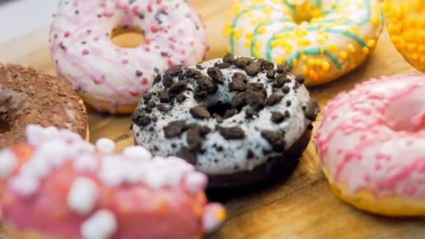 Chocolate, marshmello and candy donuts on a retro baking tray. Donuts are on a paper decorated with natural chocolate. Macro and slider shooting. Various colorful donuts. Chocolate, pink, blue donuts - Footage, Video