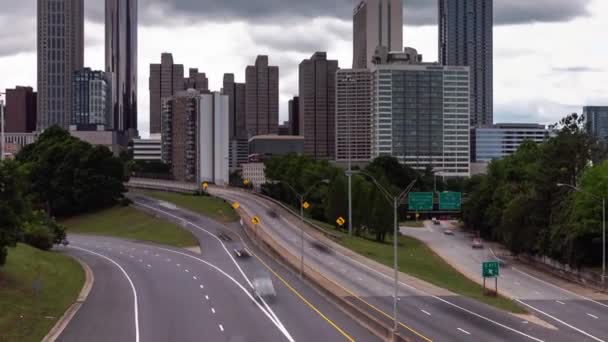 Ausblenden des Zeitrahmens der Innenstadt von Atlanta von der Jackson Street Brücke mit Blick auf die Autobahn mit Bewegungsunschärfe im Fahrzeugverkehr auf der Fahrbahn unten und schwerer Wolkendecke oben. - Filmmaterial, Video