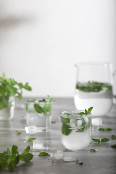 Bicchiere di acqua fredda con foglie di menta fresca e cubetti di ghiaccio. Copia spazio - Foto, immagini