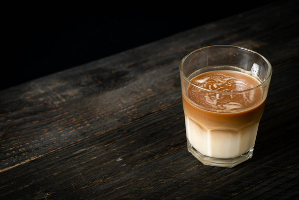 egy pohár latte kávé, kávé tejjel a fa háttér - Fotó, kép