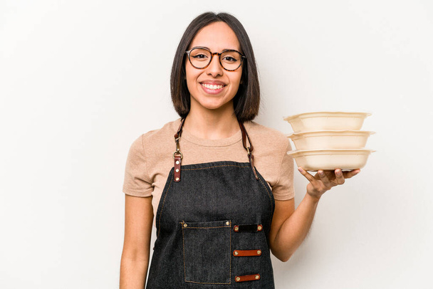 Молодая кавказская официантка, держащая посуду на белом фоне, счастливая, улыбающаяся и весёлая. - Фото, изображение