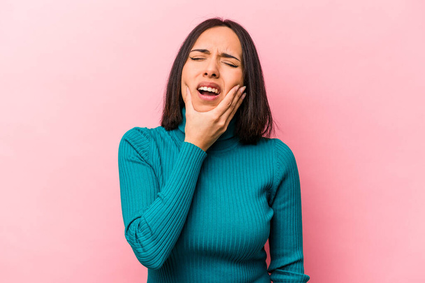 Молодая латиноамериканка, изолированная на розовом фоне с сильной зубной болью, зубной болью. - Фото, изображение