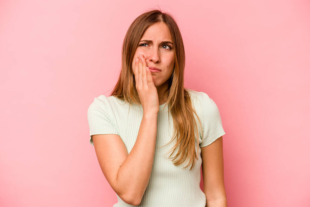 Mladá běloška žena izolované na růžovém pozadí mají silné bolesti zubů, molární bolesti. - Fotografie, Obrázek