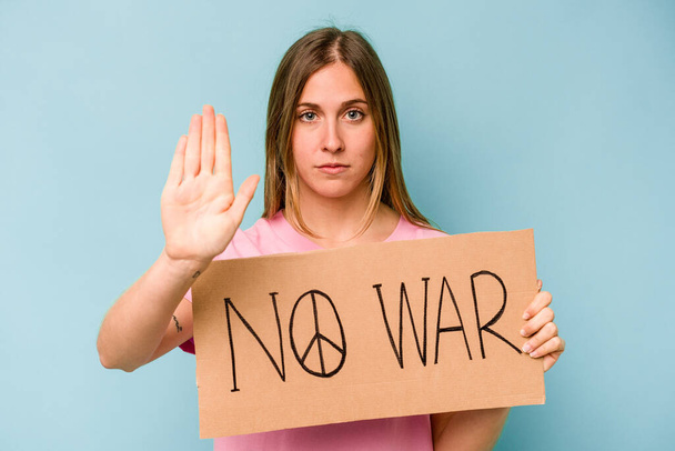 Молода біла жінка не тримає плакат війни ізольовано на синьому фоні
 - Фото, зображення