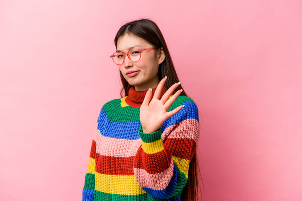 Young Chinese woman isolated on pink background rejecting someone showing a gesture of disgust. - Photo, Image