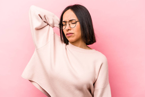 Young hispanic woman isolated on pink background tired and very sleepy keeping hand on head. - Photo, Image