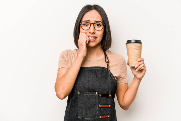 Jeune serveuse caucasienne tenant à emporter café isolé sur fond blanc ongles mordants, nerveux et très anxieux. - Photo, image