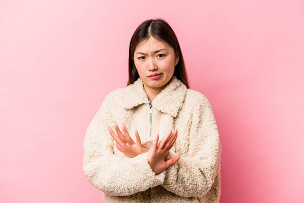 Joven mujer china aislada sobre fondo rosa haciendo un gesto de negación - Foto, imagen