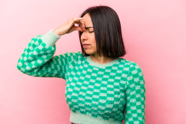 Young hispanic woman isolated on pink background having a head ache, touching front of the face. - Photo, Image