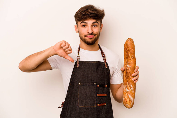 Young baker hispanic man isolated on white background showing a dislike gesture, thumbs down. Disagreement concept. - Foto, Bild