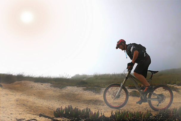 Motorsikletli bir dağ bisikletçisi okyanusun kenarında - Fotoğraf, Görsel