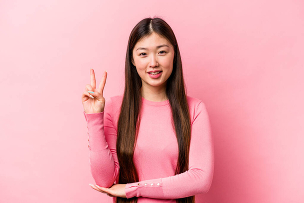 Jovem chinesa isolada no fundo rosa mostrando o número dois com os dedos. - Foto, Imagem