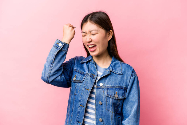 Young Chinese woman isolated on pink background celebrating a victory, passion and enthusiasm, happy expression. - Foto, afbeelding