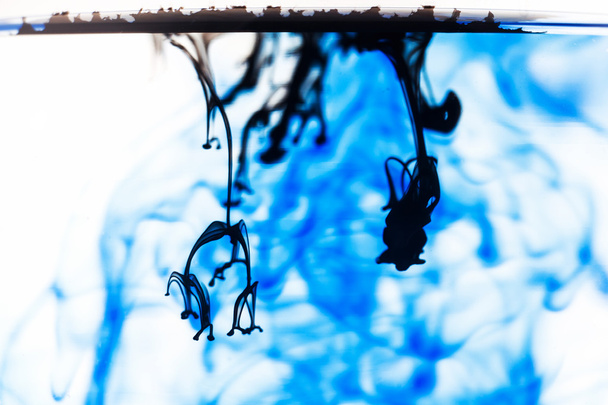 Blauwe en zwarte vloeistof in water - Foto, afbeelding
