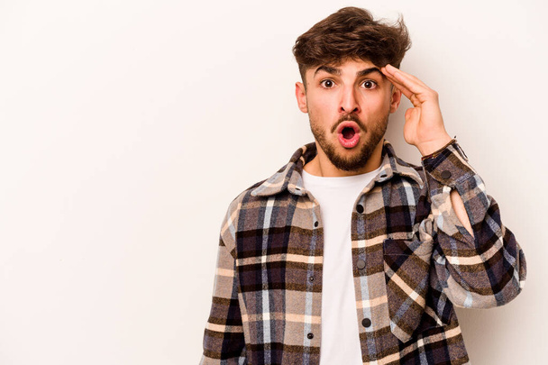 Young hispanic man isolated on white background shouts loud, keeps eyes opened and hands tense. - 写真・画像
