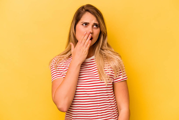 Νεαρή καυκάσια γυναίκα απομονωμένη σε κίτρινο φόντο χασμουρείται δείχνοντας μια κουρασμένη χειρονομία που καλύπτει το στόμα με το χέρι. - Φωτογραφία, εικόνα