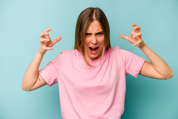 Young caucasian woman isolated on blue background screaming with rage. - Fotoğraf, Görsel