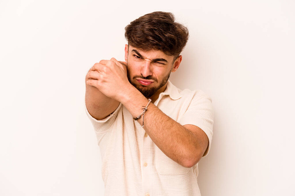 Молодий іспаномовний чоловік ізольований на білому тлі з болем в шиї через стрес, масаж і торкання рукою
. - Фото, зображення