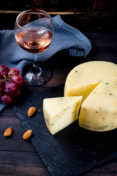 homemade cheese head with lavander on old dark wooden board and glass of wine on table. Fresh dairy product, healthy organic food. Delicious appetizer. - Foto, Bild