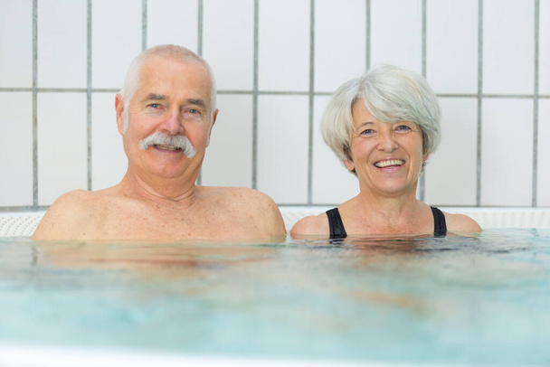 elderly couple enjoying the pool - Foto, Bild