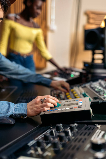 Stock photo of unrecognized male music producer working with black singer in professional music studio. - Valokuva, kuva