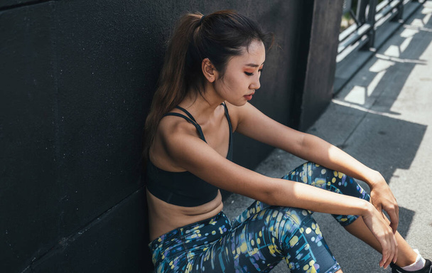 Tired Asian Woman In Sportswear Resting After Running In The City - 写真・画像