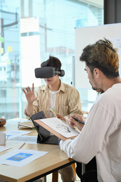 Website development team testing virtual reality headset, brainstorming on augmented reality improvement, future technology for business. - Foto, Imagen
