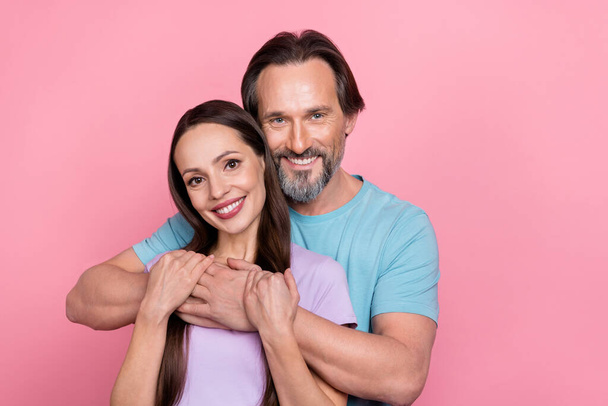 Portrait of two idyllic peaceful people embrace look camera isolated on pink color background. - Фото, изображение