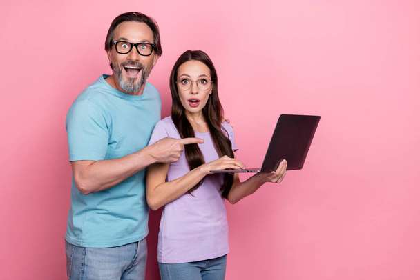 Photo of impressed good mood couple recommend you new laptop device isolated on pink color background. - Fotografie, Obrázek