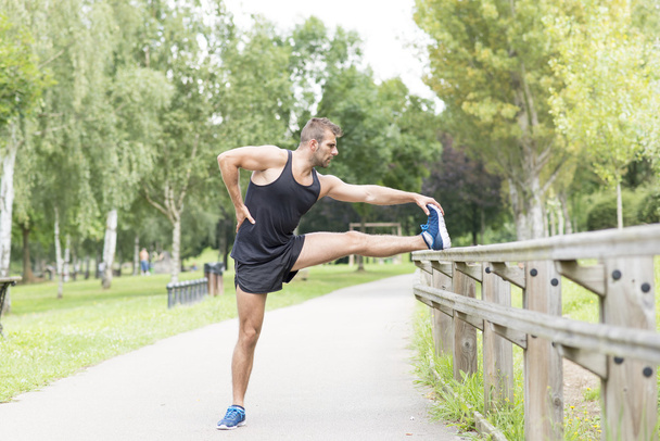 Yapan atletik güçlü erkek sağlıklı yaşam konsepti egzersiz öncesine uzanır. - Fotoğraf, Görsel