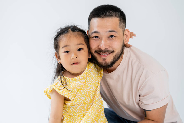 portrait of asian girl hugging happy father isolated on grey - Zdjęcie, obraz